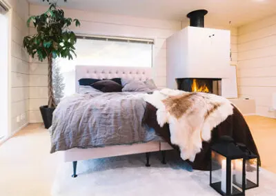 Muhkea kotimainen Unico jenkkisänky sisustettuna moderniin huoneeseen takkatulen ääreen.